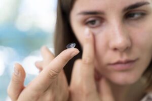 woman putting on contact lenses